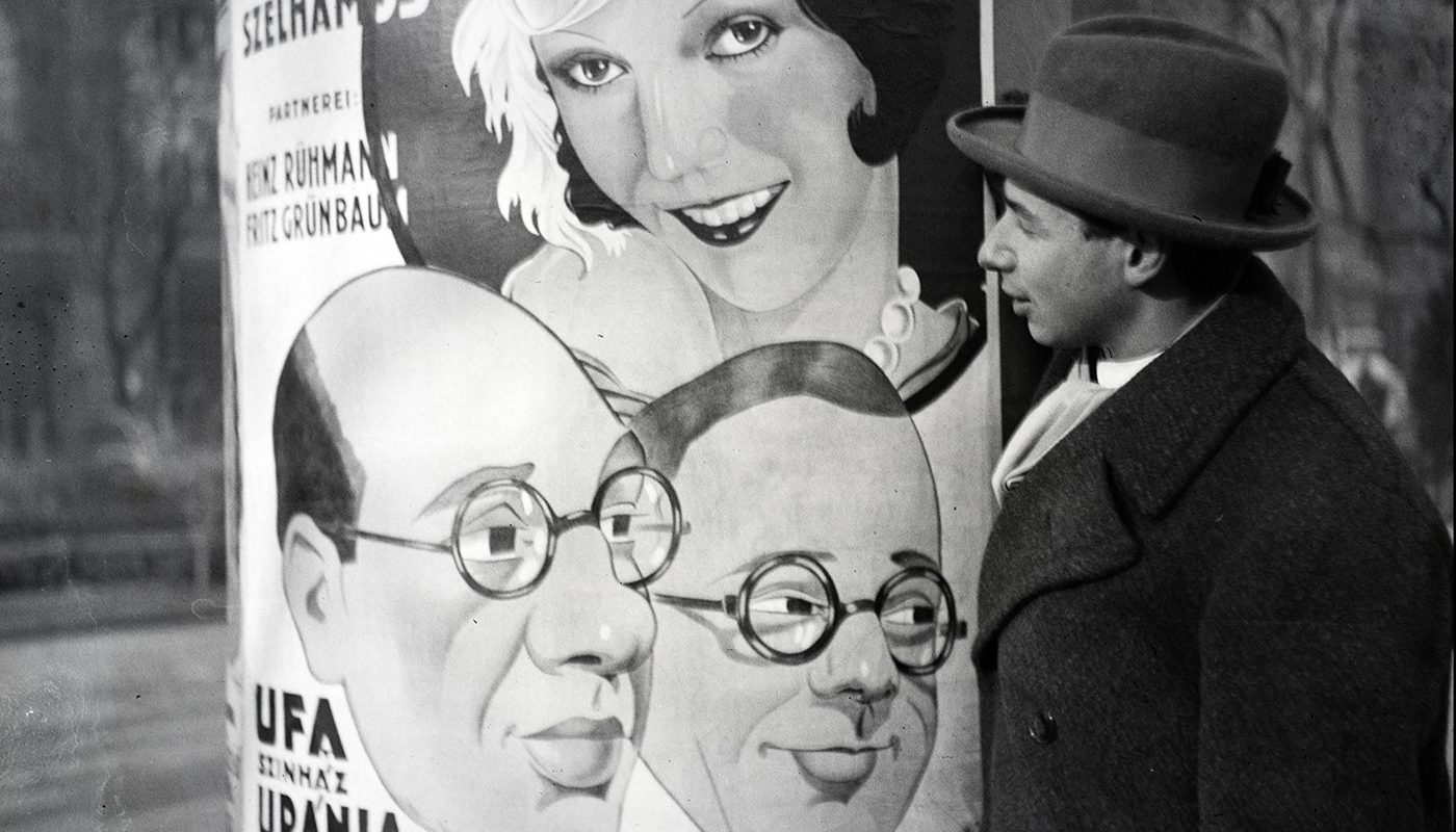 Fekete fehér kép egy férfi nézi a női plakátokat